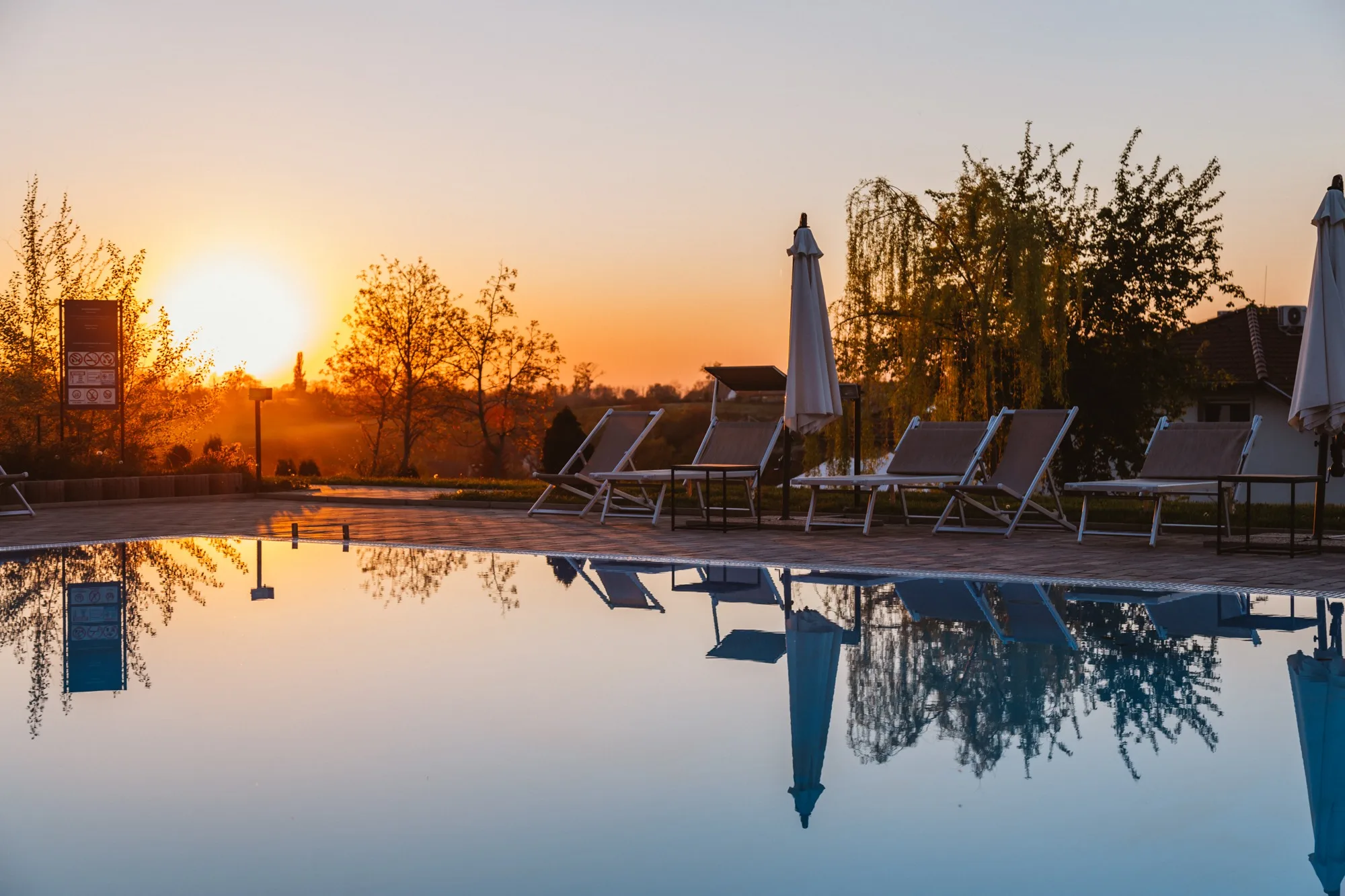 Pool terrace at sunset with lounge chairs